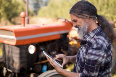 Homem controlando lavoura pelo tablet